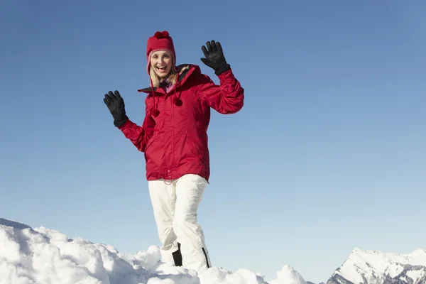 Femme debout dans la neige portant des vêtements chauds pendant les vacances de ski en Mo — Photo