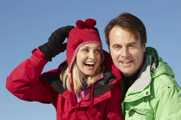 Пара стоячи в снігу теплий одяг на лижному відпочинку в М — стокове фото