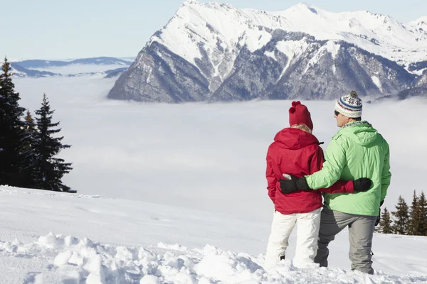 산에서 스키 휴가에 동안 마운틴 뷰를 감상 하는 커플 — 스톡 사진