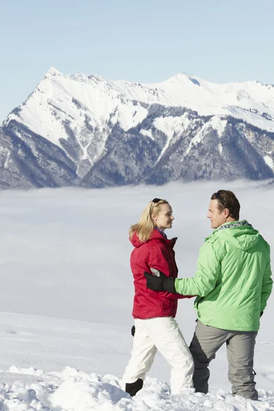Pareja admirando la vista de la montaña mientras que en vacaciones de esquí en las montañas —  Fotos de Stock