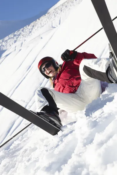 여성 스키어가 후와 함께 눈에 앉아 — 스톡 사진