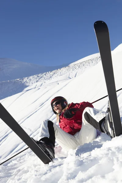Esquiadora sentada en la nieve con después de la caída — Foto de Stock