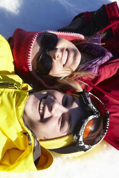 Vista aerea di madre e figlio adolescente sdraiato sulla neve sullo sci Hol — Foto Stock