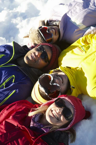 Ogólny widok nastoletnich rodziny leżącego w śniegu na narty w — Zdjęcie stockowe