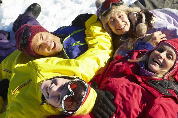 Vista aérea de la familia adolescente acostada en la nieve en las vacaciones de esquí en — Foto de Stock