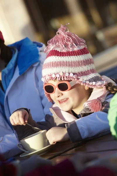 Menina nova desfrutando de bebida quente no café na estação de esqui — Fotografia de Stock