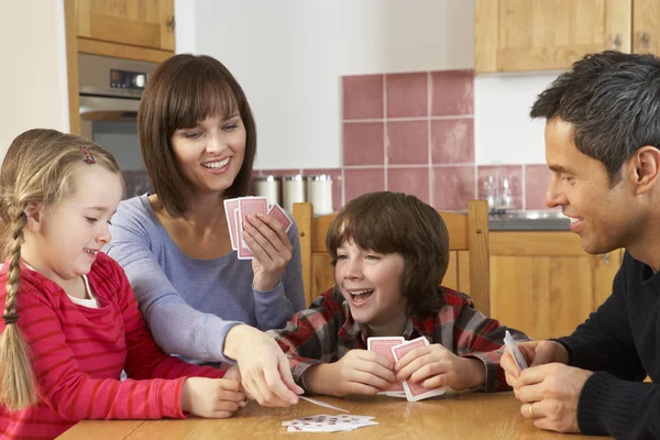 Família jogando cartas na cozinha — Fotografia de Stock