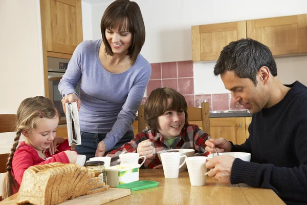 家族で台所で一緒に朝食を食べる — ストック写真