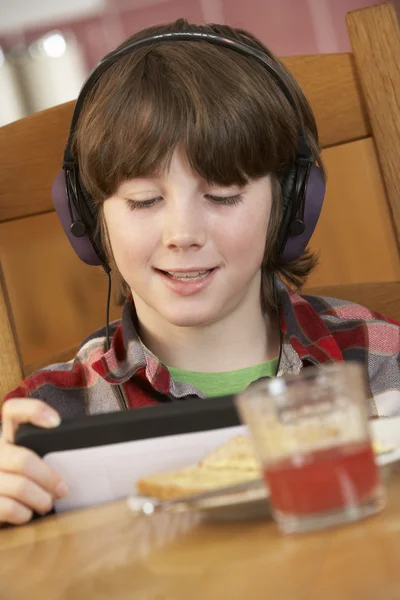 Niño usando Tablet Computer mientras come el desayuno — Foto de Stock