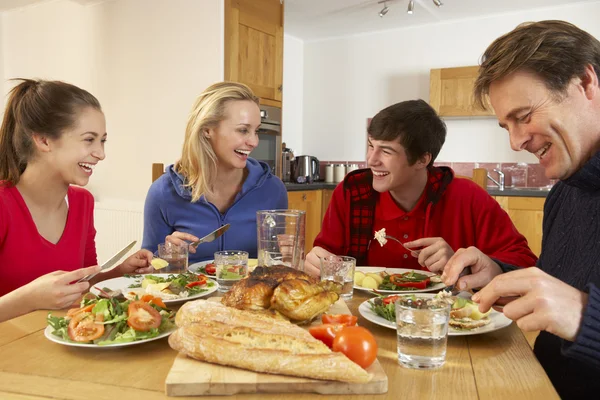 Teenage familie eten lunch samen in keuken — Stockfoto