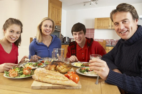 Подростковая семья обедает вместе на кухне — стоковое фото