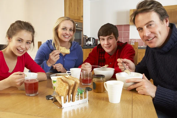 家族で台所で一緒に朝食を食べる — ストック写真