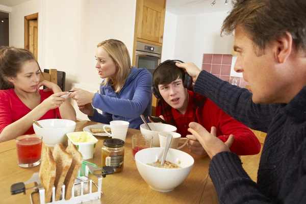 Föräldrar tar bort prylar från barn samtidigt som du äter breakfas — Stockfoto