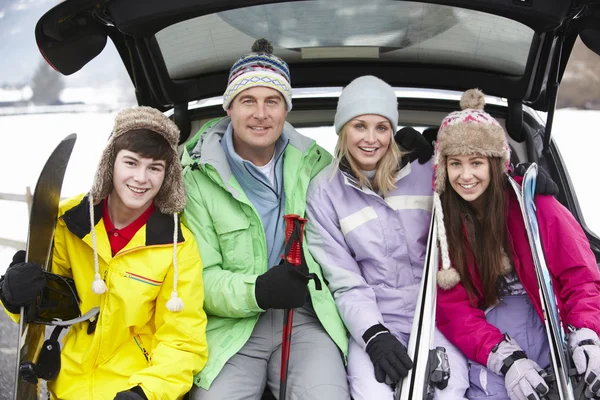 Família adolescente sentada na bota do carro com esquis — Fotografia de Stock