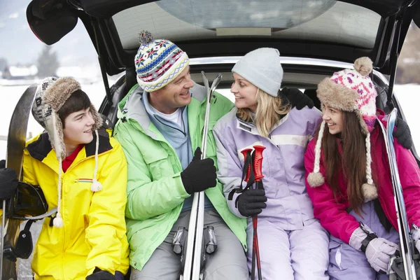 Família adolescente sentada na bota do carro com esquis — Fotografia de Stock