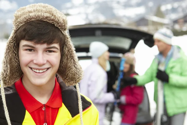 Εφηβικό αγόρι που χαμογελούσε κάμερα, ενώ η οικογένεια φορτίο σκι στην εκκίνηση του — Φωτογραφία Αρχείου