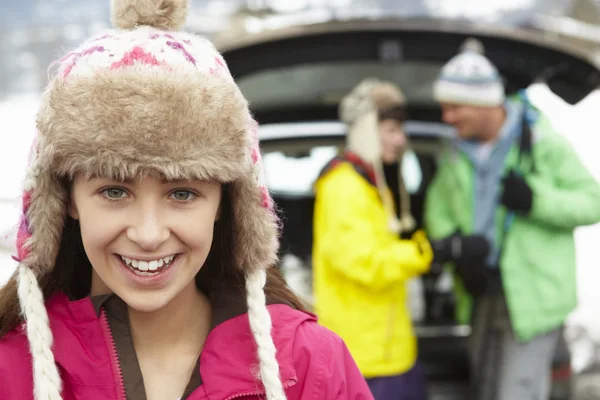 十几岁的女孩虽然家庭装载滑雪板在引导 o 在相机微笑 — 图库照片