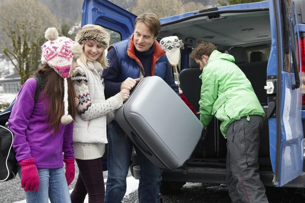 Familie beim Entladen des Gepäcks aus dem Transferwagen vor dem Chalet auf Ski — Stockfoto