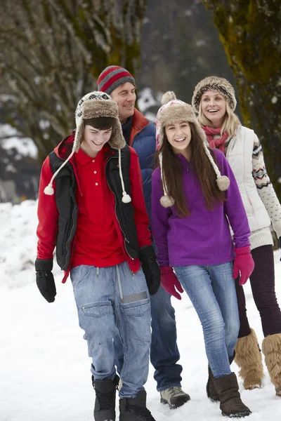 Famille adolescente marchant le long de la rue enneigée dans la station de ski — Photo