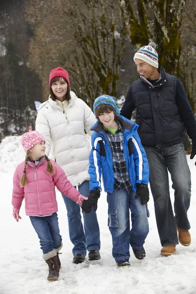 Randonnée en famille le long de la rue enneigée dans la station de ski — Photo