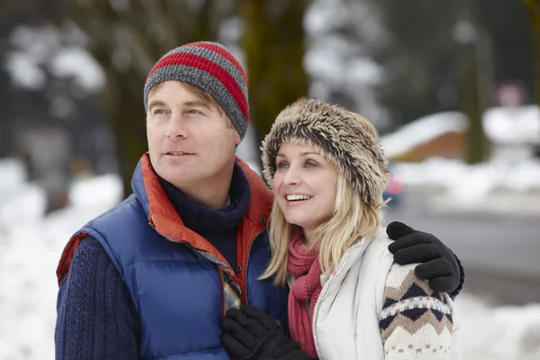 スキー場の雪に覆われた通りに沿って歩くカップル — ストック写真