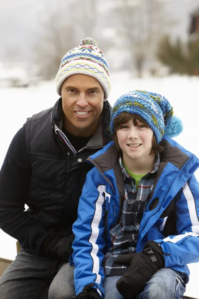 Porträtt av far och son bär vinterkläder i snöiga landar — Stockfoto