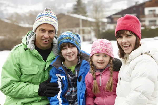 Портрет семьи в зимней одежде на заснеженном пейзаже — стоковое фото