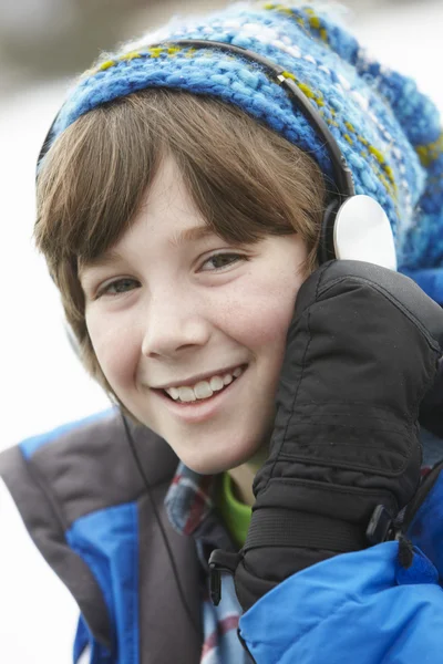 Хлопчик носить навушники і слухає музику в зимовому клубі — стокове фото
