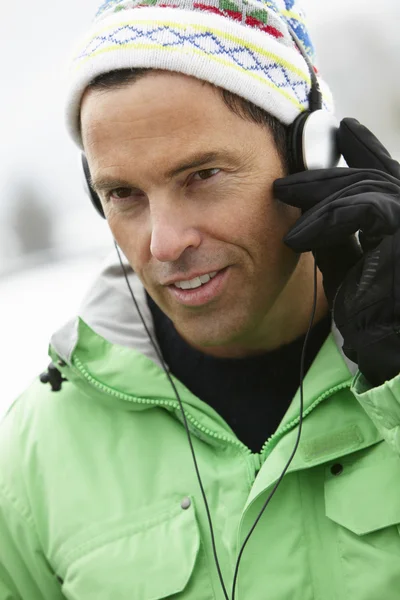 Hombre usando auriculares y escuchando música usando Winter Clo —  Fotos de Stock