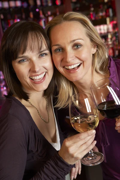 Twee vrouwen genieten van drankje samen in bar — Stockfoto
