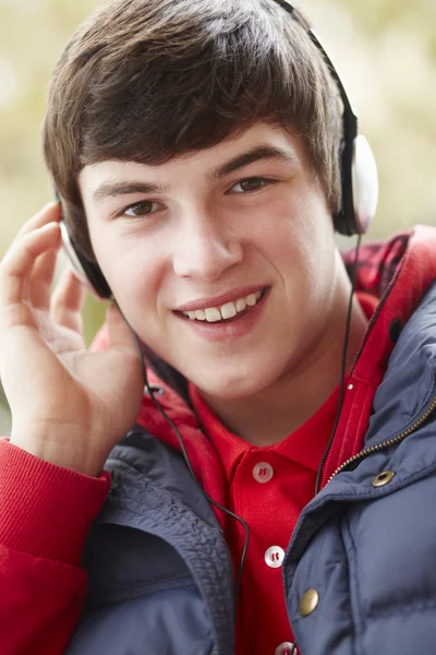 Nastoletni chłopak sobie słuchawki i słuchanie muzyki sobie wi — Zdjęcie stockowe