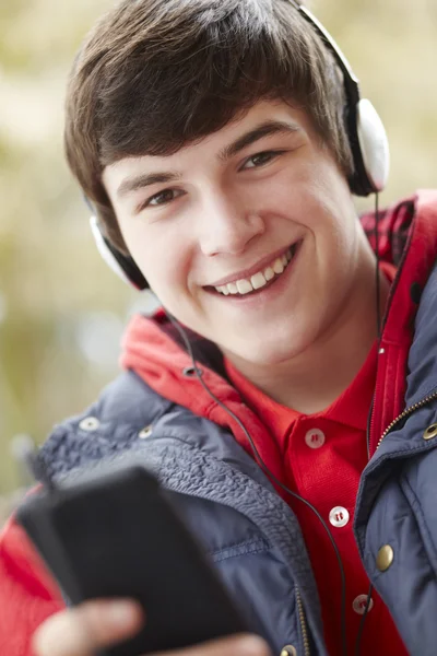 Tonårspojke bär hörlurar och lyssna på musik bär wi — Stockfoto