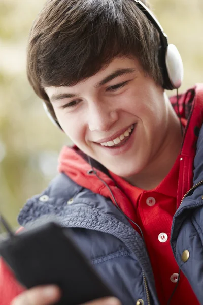 Adolescente niño usando auriculares y escuchando música usando Wi —  Fotos de Stock