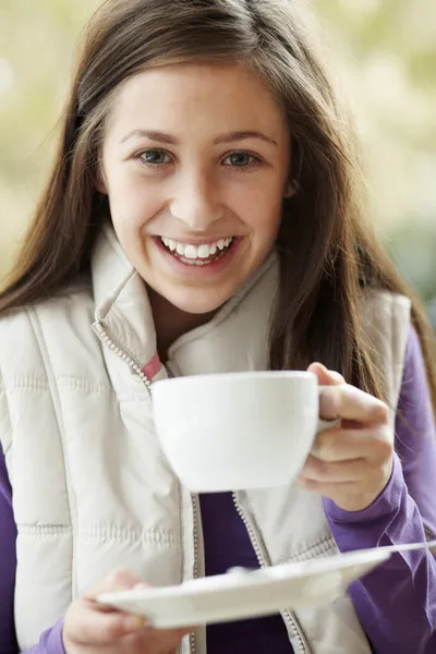 Menina adolescente no café ao ar livre com bebida quente usando o entalhe de inverno — Fotografia de Stock