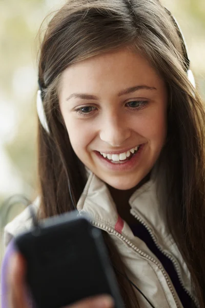 Menina adolescente usando fones de ouvido e ouvir música vestindo W — Fotografia de Stock