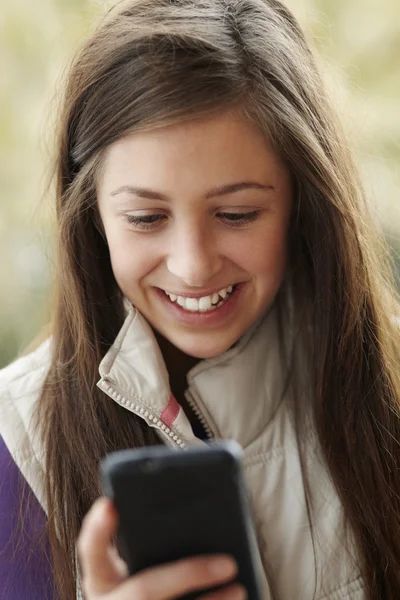 智能手机穿着冬天的衣服上十几岁的女孩发短信 — 图库照片