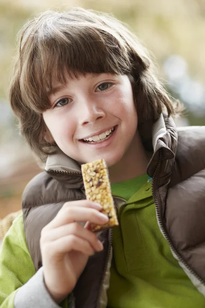 Ragazzo mangiare sano snack bar indossa vestiti invernali — Foto Stock