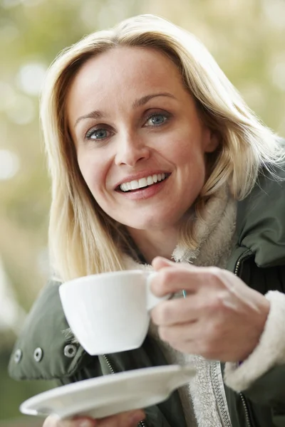 Woman In Outdoor Café With Hot Drink Wearing Winter Clothes — Stock Fotó