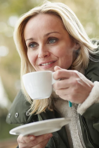 Donna in caffè all'aperto con bevanda calda che indossa vestiti invernali — Foto Stock