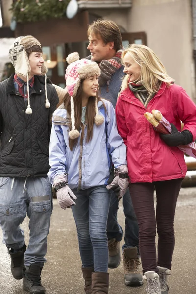 Εφηβική οικογένεια περπατώντας κατά μήκος του δρόμου χιονισμένη πόλη στο χιονοδρομικό κέντρο — Φωτογραφία Αρχείου