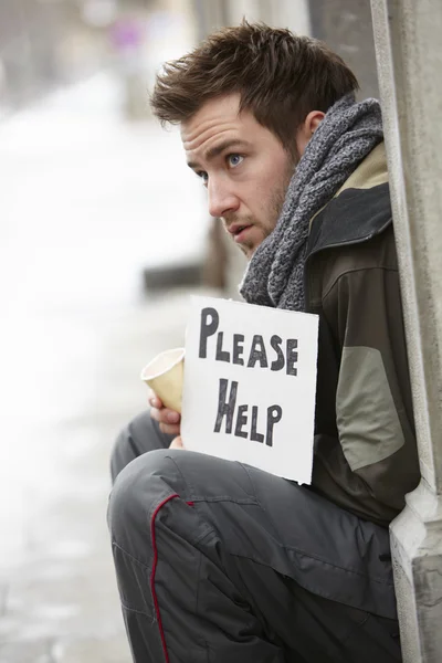 Hombre joven sin hogar mendigando en la calle —  Fotos de Stock