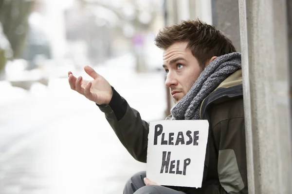 Hombre joven sin hogar mendigando en la calle — Foto de Stock
