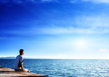 Young man relax siting on pier clipart