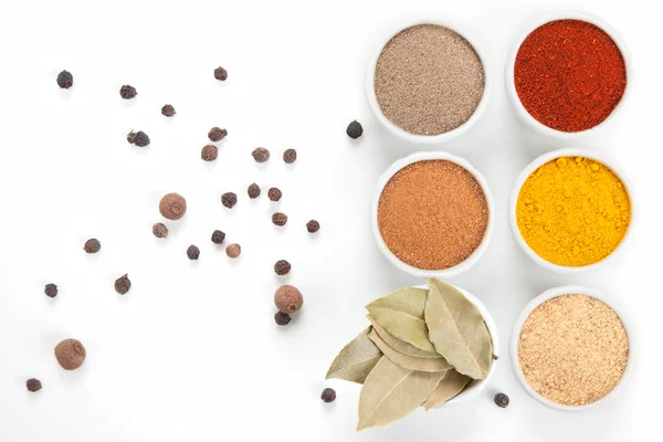 Different spices in white bowls isolated on white background. — Stock Photo, Image