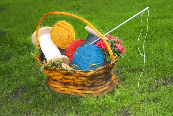 Blomsterkurv med tråd, nål, bolde til strikning - Stock-foto