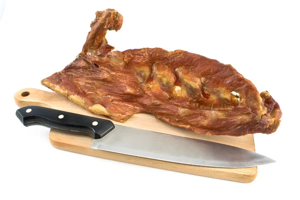 Smoked pork bone on wooden board with knife — Stock Photo, Image