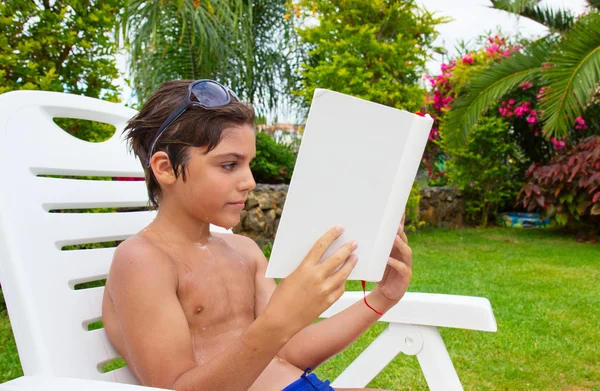 Pojke läser på sommaren gräsmatta — Stockfoto