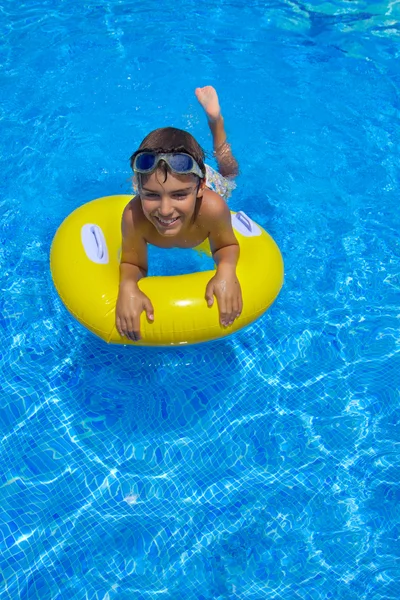 Menino nadando no anel de borracha na piscina — Fotografia de Stock