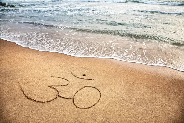 stock image Om symbol on the beach