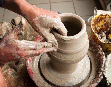 Potter creating earthen jar on the circle clipart